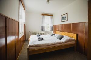 科热诺夫Turnovská chata的一间卧室配有一张大床和木制床头板