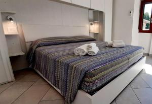 韦尔巴尼亚CASA DELLE ROSE 2的一间卧室配有带毛巾的床
