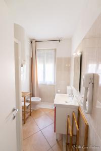 莱科幸运之家住宿加早餐旅馆的白色的浴室设有水槽和卫生间。