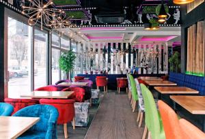贝尔格莱德ESTRADA Lux的餐厅设有多彩的桌椅和窗户。