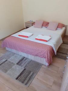 阿拉德Apartament Andreas的一间卧室配有一张带粉色床单和枕头的床。