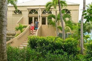 圣约翰噶罗斯柏银特度假酒店的男人和女人在房子前面走楼梯