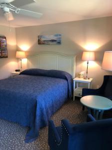 巴港Island Place的一间卧室配有一张床、两把椅子和一张桌子