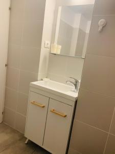 南埃福列Apartament Maria的白色的浴室设有水槽和镜子
