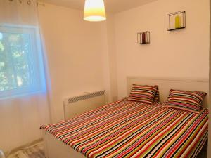 南埃福列Apartament Maria的一间卧室配有一张带两个条纹枕头的床
