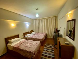马特鲁港Semiramis Hotel Royal Palace的酒店客房设有两张床和电视。