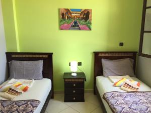 丹吉尔TanjaLucia Hostel的绿墙客房内的两张床