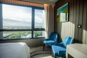 台东丽丽大酒店的酒店客房设有两把蓝色椅子和窗户。