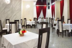 斯兰默多瓦Vila Teleconstructia的一间设有白色桌椅和红色窗帘的用餐室