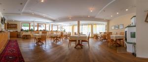 齐勒河谷采尔Hotel Garni Elisabeth的大型用餐室配有桌椅