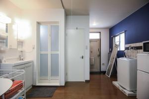 松户市松戸駅ｽｸﾞ 1DK 出張に旅行に Nomad松戸宿019的厨房配有白色冰箱和蓝色的墙壁