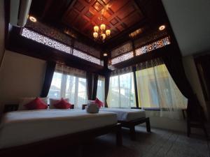 南邦Ban Mae Boonthong的一间卧室设有两张床、窗户和天花板