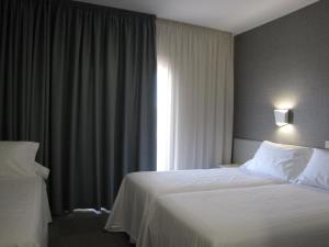 桑亨霍Hotel Ton的酒店客房设有床和窗户。