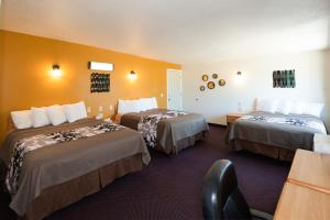 沙姆罗克Western Motel的酒店客房设有两张床和一张桌子。