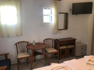 普拉迪斯亚罗斯浪漫酒店的配有桌椅和电视的客房