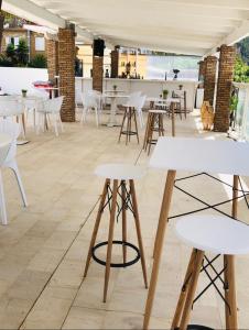 Kato RodiniHotel Rodini的一间设有白色桌子和白色椅子的餐厅