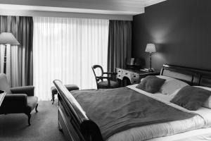 德哈恩杜尼福乡村别墅酒店的一间卧室配有一张大床和一张桌子及椅子