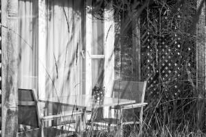 德哈恩杜尼福乡村别墅酒店的玻璃桌和两把椅子坐在窗前