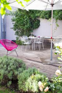 埃朗根斯塔德豪斯酒店的庭院配有桌椅和遮阳伞。