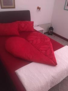 福纽德MG Apartmanház的红色的床,配有白色床单和红色棉被