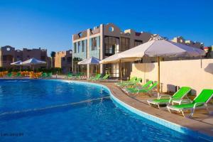 Dawwār Abū Duray‘ah ‘Abd al KarīmGreen Leaves Hotel的一个带绿色躺椅和遮阳伞的游泳池