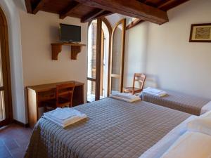 阿夸桑塔泰尔梅Albergo Ristorante Terme的一间卧室配有两张床、一张桌子和一台电视。