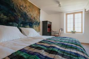 金洛伊Amitié的卧室配有一张大床,墙上挂有绘画作品