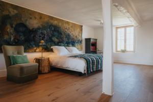 金洛伊Amitié的卧室配有一张床,墙上挂有绘画作品