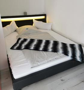 巴特菲尔伯尔Arthouse Apartment 2的一张配有黑白床单和枕头的床