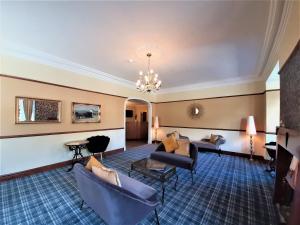 巴特米尔Buttermere Court Hotel的酒店大堂设有长沙发、椅子和吊灯。