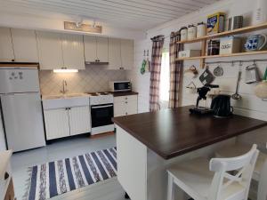 耶姆赛Villa Kesäranta的厨房配有白色橱柜和木制台面