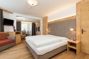 圣维吉利奥Residence Garni Stella的酒店客房设有一张大床和一张沙发。