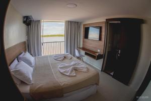 博阿维斯塔Hotel Orla do Rio Branco的酒店客房设有床和窗户。