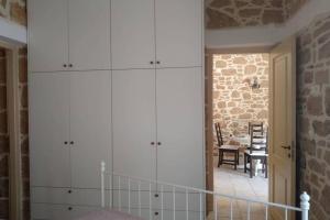 锡蒂亚Traditional stone house的一间设有白色橱柜和砖墙的房间