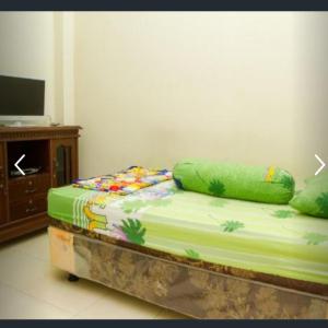 丹戎潘丹Penginapan Sriwijaya的配有电视和床边镜的房间里一张床位