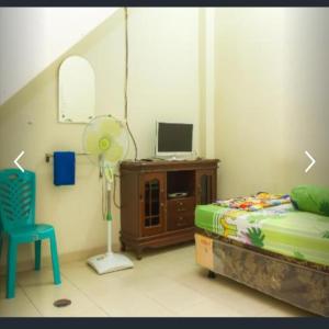 丹戎潘丹Penginapan Sriwijaya的一间卧室配有一张床、风扇和椅子