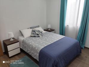 QueimadaVarandas do Basalto的一间卧室配有一张带蓝色毯子的床