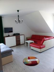 Brodnica DolnaWilla Brodnica的客厅配有红色的沙发和桌子