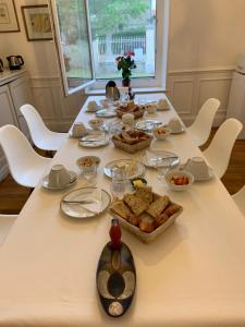 萨林德吉罗恩倪温卡马格酒店的一张长桌子,上面有食物,还有白色的椅子