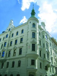 维也纳野趣膳食酒店的一座白色的建筑,上面有一座塔
