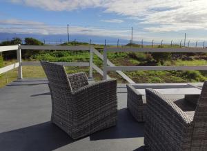 QueimadaVarandas do Basalto的庭院设有藤椅、桌子和围栏
