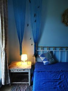 MatkuleGold Sun Zelta Saule的一间卧室配有一张带蓝色窗帘的床和一把椅子