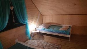 克罗科瓦Domki Magnolia的小木屋内的小房间,配有一张床