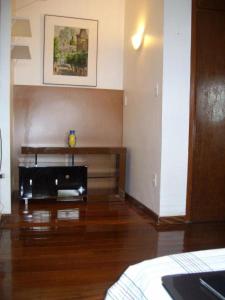 贝洛奥里藏特Apartamento com Hidro的客厅铺有木地板,配有桌子。