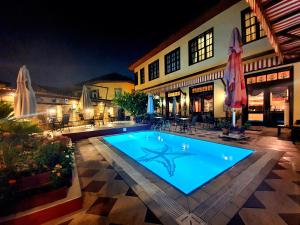安塔利亚Eski Masal Hotel - Special Class的一座游泳池,在晚上在建筑物前