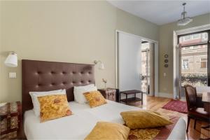 波尔图Mouzinho 244 - Porto Houses & Suites的卧室配有一张带黄色枕头的大型白色床。