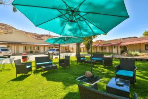 摩押莫阿布冒险客栈的庭院配有桌椅和遮阳伞。