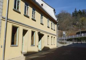 格赖茨Pension zum Hirschstein的街道边的黄色建筑