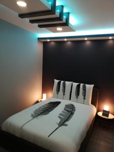 梅尔·莱斯·拜恩斯Appartement moderne avec balnéothérapie的一间卧室配有一张带两只羽毛的床。