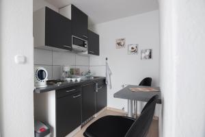 弗伦斯堡Maxbed的一间小厨房,配有黑色橱柜和一张桌子